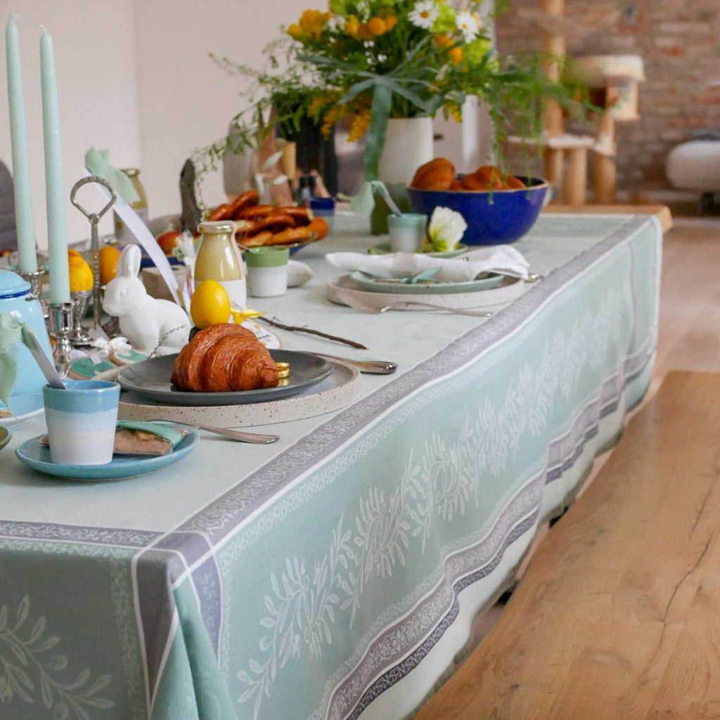 Diese Jacquard-Tischdecke aus reiner Baumwolle mit Anti-Flecken-Behandlung zeigt die Motive der Provence mit ihren Olivenzweigen in hellgrünen Farben.