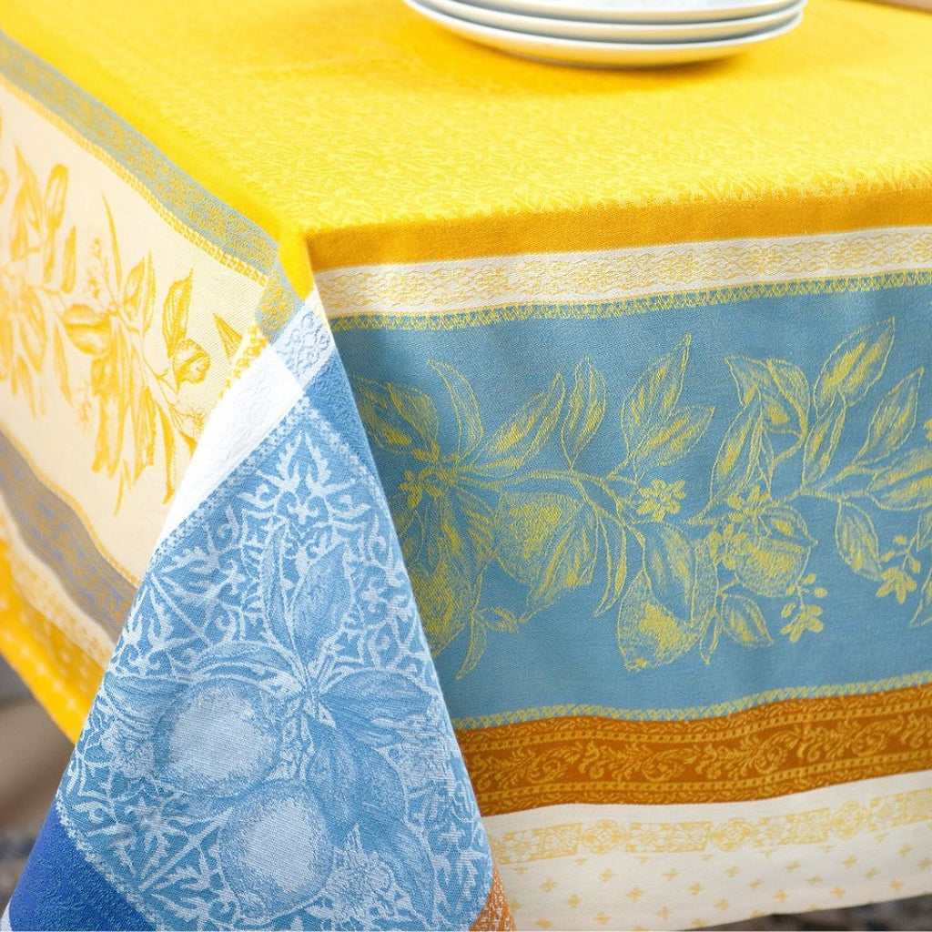 Diese wunderschöne Tischdecke in intensiven Gelb- und Blautönen erinnert an den Himmel der Provence. Hergestellt aus hochwertigem Jacquardstoff, verziert mit mediterranen Mustern und Zitronen, wird sie Ihrem Tisch eine frische und lebhafte Note verleihen. Perfekt für ein sommerliches Ambiente und um Ihre Gäste zu begeistern.