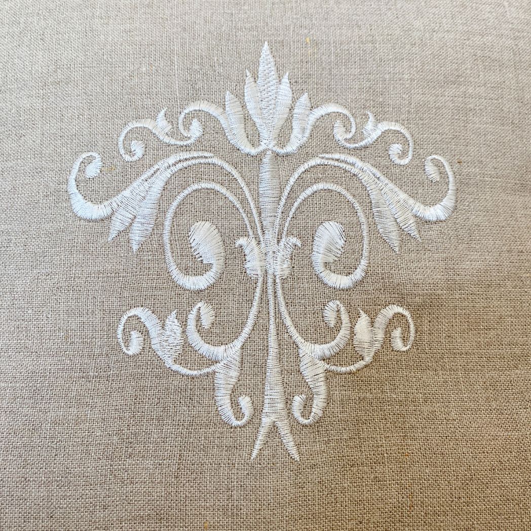 Kissenbezug aus reinem Leinen mit dekorativer Ornament-Stickerei. Dieses Dekokissen ist beige mit weisser Stickerei.